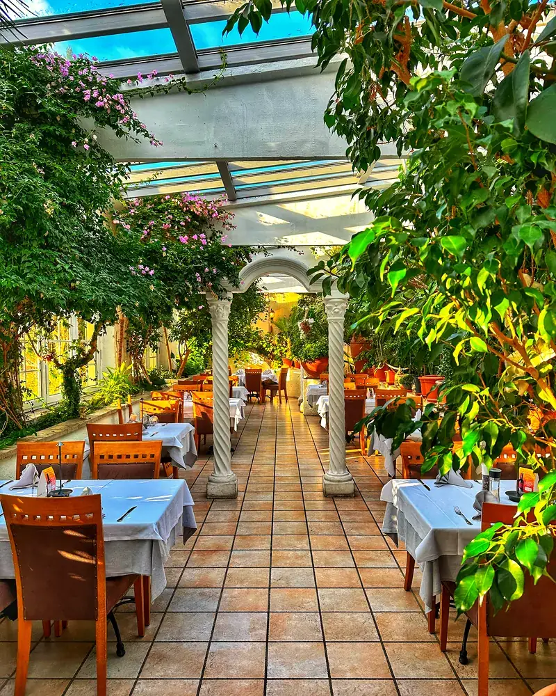 Weißer Säulengang mit Bougainvillea im Abendlicht