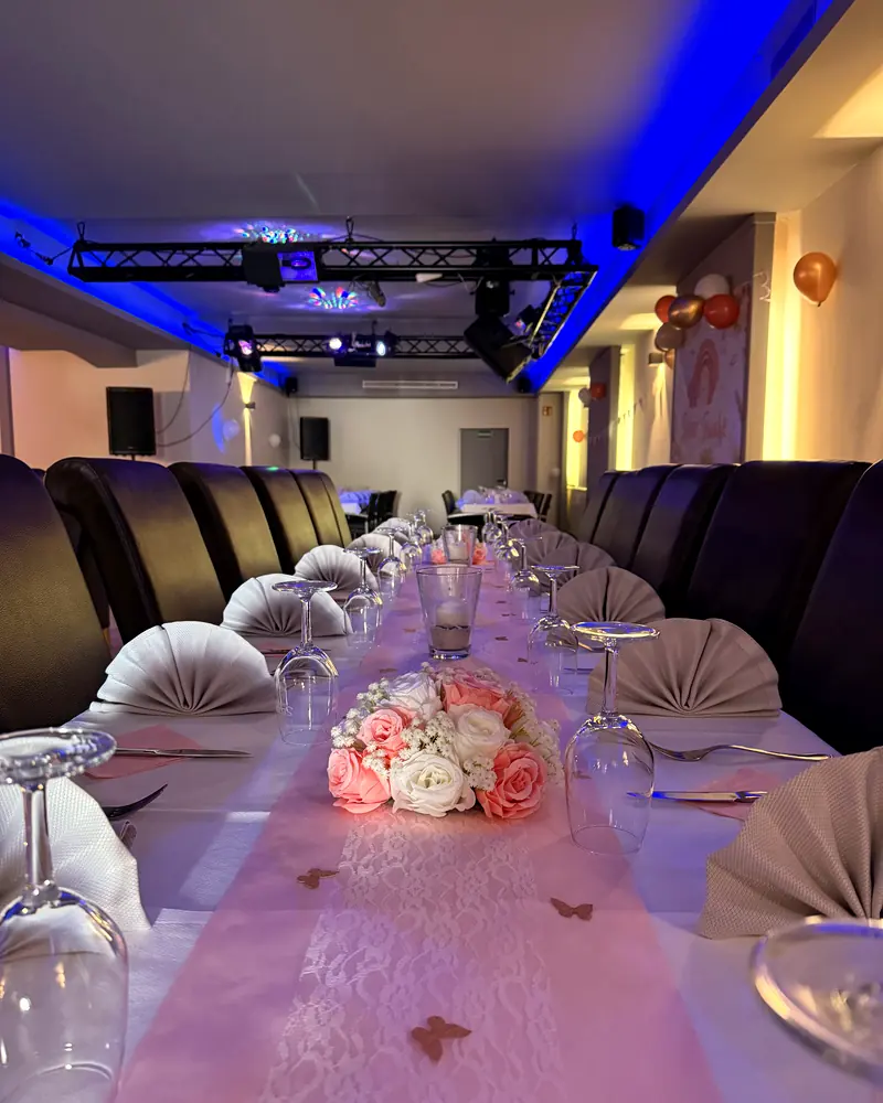 Eventraum mit stimmungsvoller Beleuchtung und festlich gedeckter Tafel